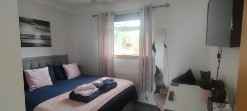 a small bedroom with a bed with a window at KINGHORN - Private room, ensuite & sunroom with Fab views in Kinghorn