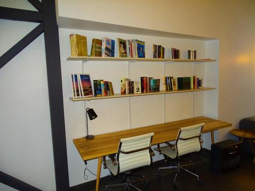 een kamer met een tafel met stoelen en boeken bij BHB Hotel Boutique in Santiago