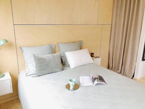 a bed with a book and a vase on it at Les bungalows de la Torche - B°3 West in Plomeur