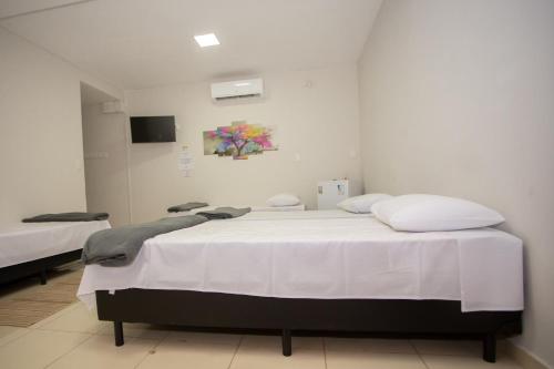 ein Krankenhauszimmer mit einem Bett mit weißer Bettwäsche in der Unterkunft Ribeiro Flat in Araxá