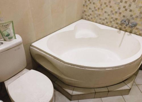 een badkamer met een toilet en een bad bij Felix guest house in Tegal