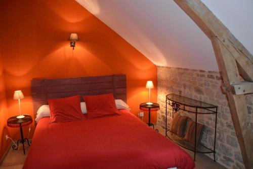 a bedroom with a red bed in an attic at Les Chaufourniers/L'Etable in Crouay