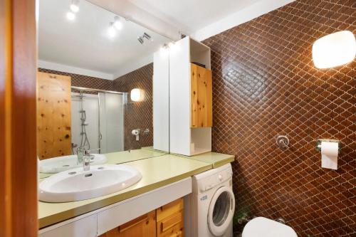 a bathroom with a sink and a washing machine at Augusta Praetoria Pila in Gressan