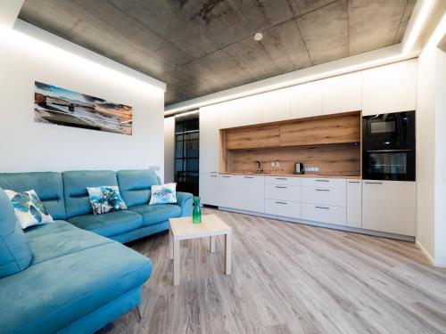 a living room with a blue couch and a table at Cozy Apartment Vilnius in Vilnius