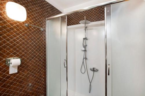 a shower with a glass door in a bathroom at Ciel Bleu Pila in Pila