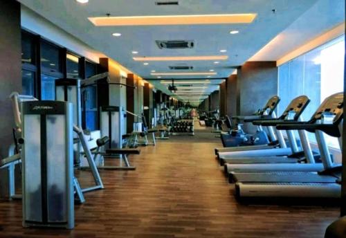 a gym with a row of treadmills at Atlantis Residence Melaka by YouBNB Homestay in Melaka