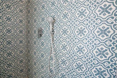 a shower in a bathroom with blue and white tiles at Casa Machado in Lagos