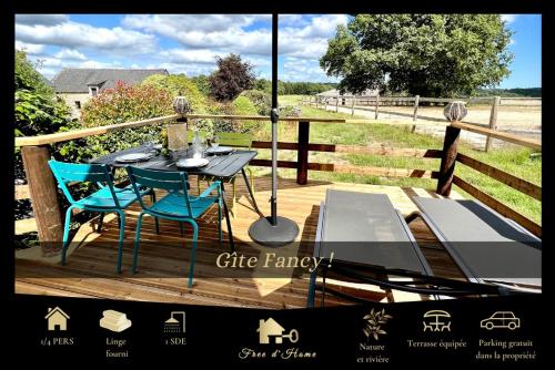 a wooden deck with a table and chairs on it at Gîte Fancy, Vallée du Scorff, Nature 2-4 personnes in Arzano