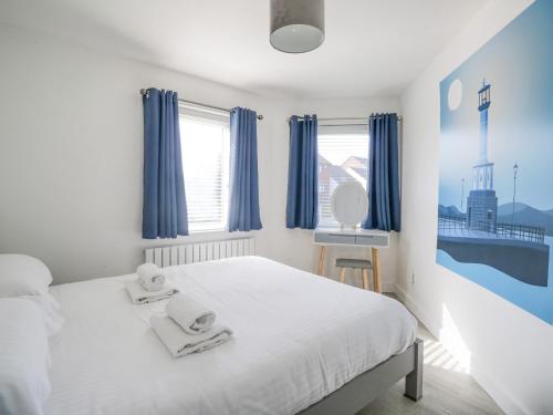 a bedroom with a white bed with towels on it at Alauna View in Maryport