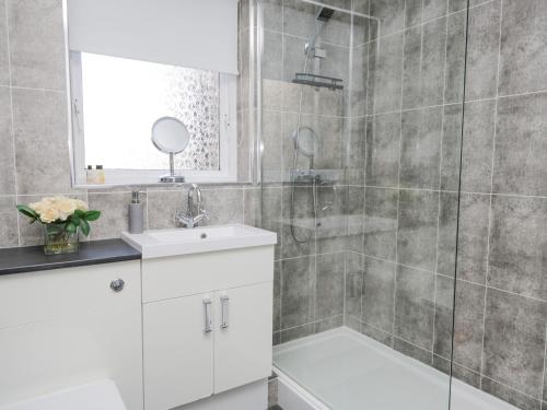 a bathroom with a white sink and a shower at Alauna View in Maryport