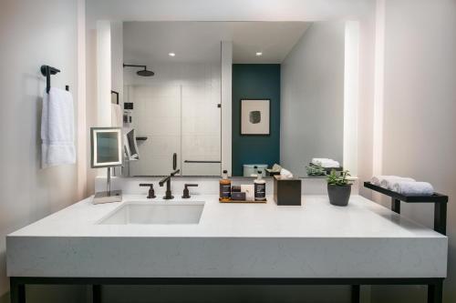 a white bathroom with a sink and a shower at The Royal Sonesta Washington DC Capitol Hill in Washington