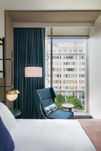 a bedroom with a bed and a chair and a window at The Royal Sonesta Washington DC Capitol Hill in Washington