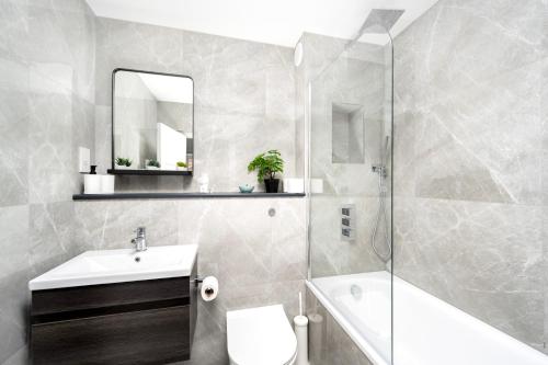 a bathroom with a sink toilet and a shower at Charming Apartment in the Pleydell Estate in London