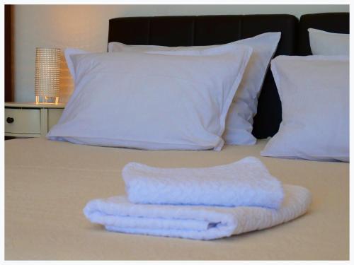 a stack of towels sitting on top of a bed at The Peninsula in Primošten