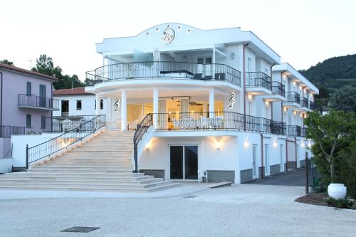 un grande edificio bianco con scale di fronte di Ludwig Boutique Hotel & Spa a Bolsena