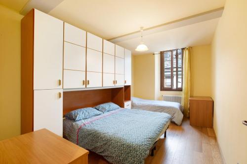 a small bedroom with two beds and a table at Augusta Praetoria Aosta in Aosta