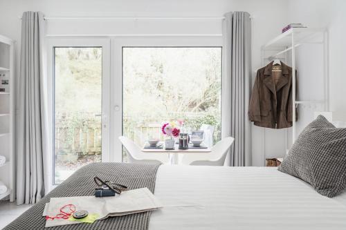een witte slaapkamer met een bed en een tafel bij Siskin Guest Suite in Kinrara
