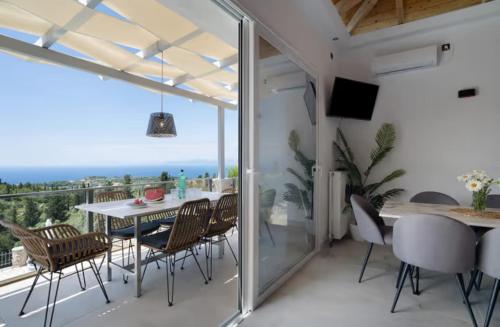 a dining room with a table and chairs and a balcony at Key Villas in Tsoukalades