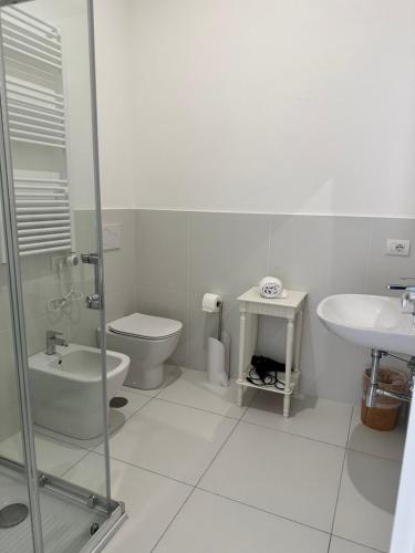 a white bathroom with a toilet and a sink at Sky Suite Blue Pomezia in Pomezia