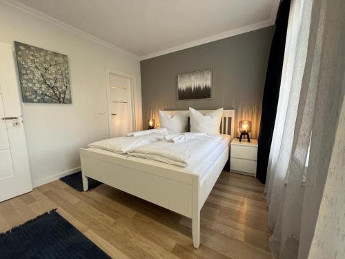 1 dormitorio con 1 cama con sábanas y almohadas blancas en 130m² Designerwohnung mit 2 Vollbädern en Gera