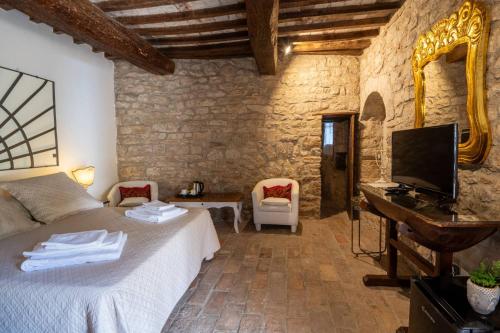 a bedroom with a bed and a desk and a television at Castello Valenzino in Umbertide