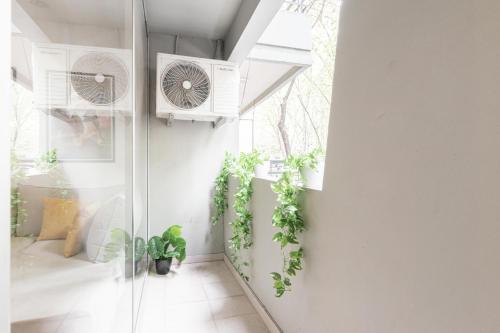 une chambre avec une fenêtre et des plantes sur le mur dans l'établissement Fliphaus Oro 2200 - Lux Duplex Palermo Soho, à Buenos Aires