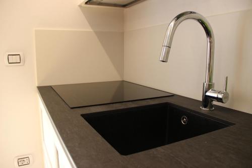 a kitchen counter with a sink and a faucet at Appartamento Contolini in Mazzin