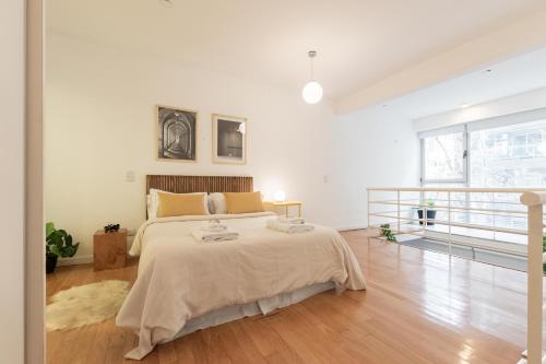 布宜諾斯艾利斯的住宿－Fliphaus Oro 2200 - Lux Duplex Palermo Soho，白色卧室设有一张大床和一个阳台