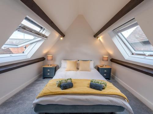 um quarto com uma cama grande e 2 janelas em Pass the Keys Dahlia Contemporary town centre apartment em Shrewsbury
