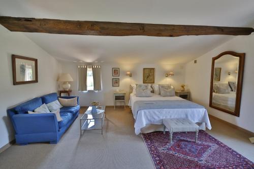 sypialnia z łóżkiem i niebieską kanapą w obiekcie Hotel Le Mas Trilles w mieście Céret