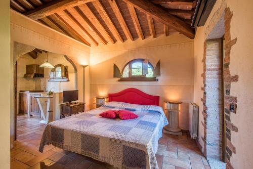 een slaapkamer met een bed met een rood hoofdeinde bij Appartamento il Pino in Rapolano Terme