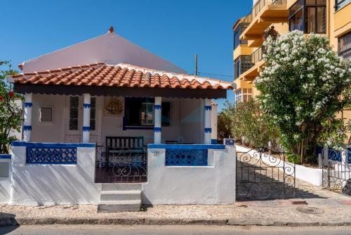una casa blanca con una puerta y una valla en BLife Faro Beach Hostel, en Faro