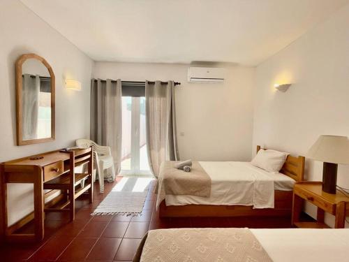 - une chambre avec 2 lits, un bureau et un miroir dans l'établissement 1bedroom duplex beach apartment, à Carvoeiro