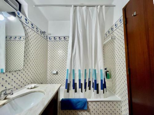 La salle de bains est pourvue d'un lavabo et d'un rideau de douche. dans l'établissement 1bedroom duplex beach apartment, à Carvoeiro