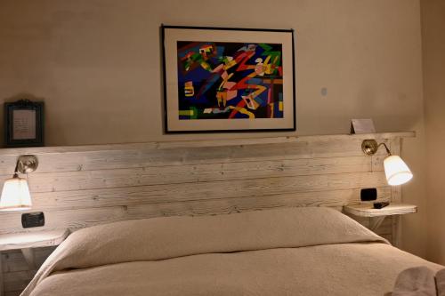 a bedroom with a bed and a painting on the wall at Domus Aurea in Saluzzo