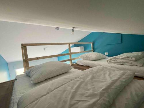 2 Betten in einem Zimmer mit blauer Wand in der Unterkunft Charmant Studio - Jacuzzi/Jardin in Andernos-les-Bains