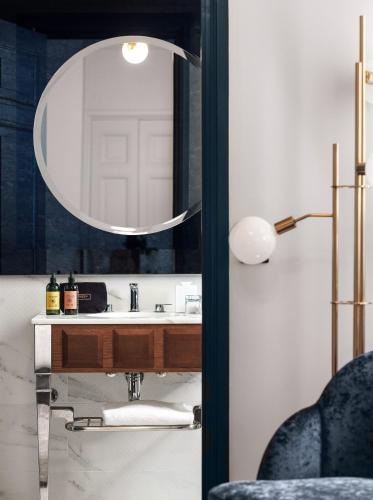 une salle de bain avec un lavabo et un miroir dans l'établissement M Social Hotel Paris Opera, à Paris