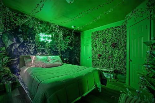 a green bedroom with a bed with plants on the walls at TheHottieHouse: Fun Fantasy Experience Apt On Blvd in Philadelphia