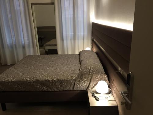 a bedroom with a bed with a headboard and lights at Foresteria Levi in Venice