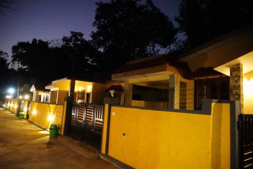 a row of houses at night with a fence at RICHBERRY- A Premium Plantation Villa's in Suntikoppa
