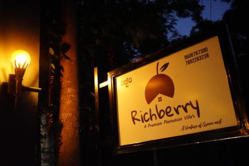 a sign on the side of a building with an umbrella at RICHBERRY- A Premium Plantation Villa's in Suntikoppa