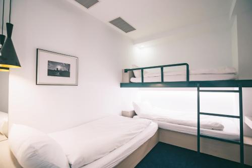 台北的住宿－美寓藝術文旅 Meistay Art Gallery Hotel，一间卧室配有两张双层床和一盏灯。