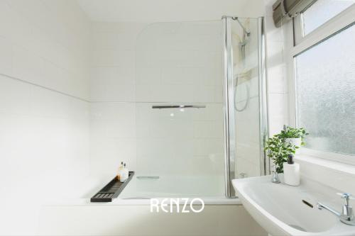 a white bathroom with a shower and a sink at Bright and Warm 3-bed Home in Nottingham by Renzo, Driveway, Smart TV with Netflix! in Nottingham
