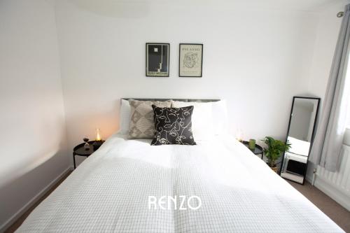 a bedroom with a bed with white sheets and pillows at Bright and Warm 3-bed Home in Nottingham by Renzo, Driveway, Smart TV with Netflix! in Nottingham