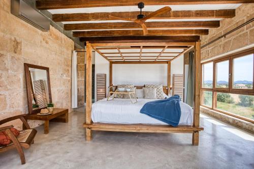 - une chambre avec un lit et un ventilateur de plafond dans l'établissement Finca Son Coranta, à Campos