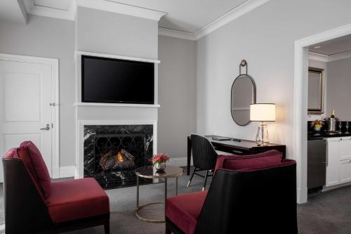 a living room with a fireplace with a tv on the wall at Waldorf Astoria Chicago in Chicago