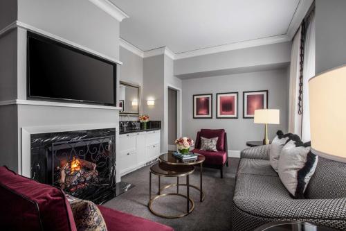 a living room with a fireplace and a flat screen tv at Waldorf Astoria Chicago in Chicago