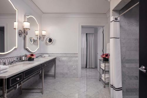 a bathroom with two sinks and two mirrors at Waldorf Astoria Chicago in Chicago