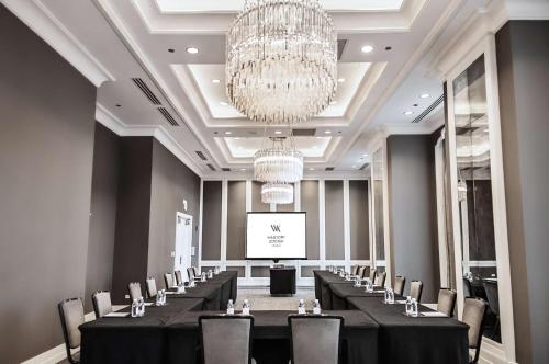 a conference room with tables and chairs and a chandelier at Waldorf Astoria Chicago in Chicago