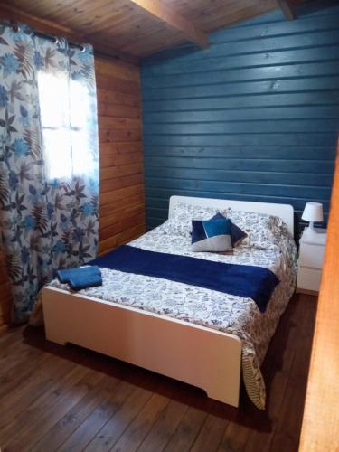 1 dormitorio con 1 cama con pared azul en Refugio do Lentinho, en Entre Ambos os Rios